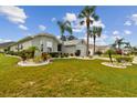 Single-story house with palm trees and well-maintained lawn at 1119 Villeroy Dr, Sun City Center, FL 33573