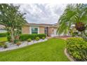 Landscaped exterior of tan one-story home at 736 Mccallister Ave, Sun City Center, FL 33573