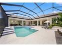 Inviting screened-in pool and spa area with lounge chairs and a view of the home's interior at 9276 Starry Night Ave, Sarasota, FL 34241