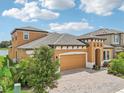 Two-story house with a two-car garage, and a nicely landscaped yard, next to a lake at 12818 Boggy Creek Dr, Riverview, FL 33579