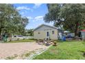 Large brick paved backyard with a spacious grassy area and mature trees at 702 12Th W Ave, Bradenton, FL 34205