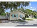 Quaint yellow house with teal shutters and a fenced yard, offering curb appeal at 702 12Th W Ave, Bradenton, FL 34205