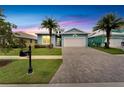 Two-story home with a light blue exterior, palm trees and driveway at 567 Bimini Bay Blvd, Apollo Beach, FL 33572