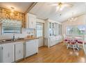 Bright kitchen with white cabinets, wood floors and dining area at 37743 Mission Hills Ave, Zephyrhills, FL 33541