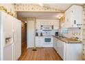 Efficient kitchen with white appliances and wood flooring at 37743 Mission Hills Ave, Zephyrhills, FL 33541