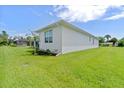 Landscaped side yard with neat grass and mature plantings at 6999 Burnsville St, Englewood, FL 34224