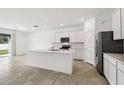 Bright, white kitchen features stainless steel appliances and a spacious island with breakfast bar at 4265 Big Sky Dr, Spring Hill, FL 34604