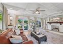 Open-concept living room featuring a painted brick fireplace, beamed ceiling, and backyard access at 608 Armada S Rd, Venice, FL 34285