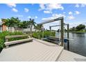 Exterior view of a private boat lift and wooden dock with a bench overlooking the calm water at 6404 Key Island Ave, Apollo Beach, FL 33572