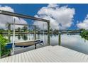 Exterior view of a private boat lift and wooden dock overlooking the calm water in a serene waterfront community at 6404 Key Island Ave, Apollo Beach, FL 33572