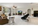 Bright living room with tile floors, ceiling fan, and large TV at 16332 Chief Dr, Hudson, FL 34667