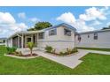 Well-maintained manufactured home with attractive landscaping and a paved driveway at 122 E Saint Annes Cir, Apollo Beach, FL 33572