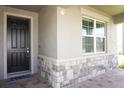 Front entry with dark wood door and stone accents at 5776 Newberry Pines Ave, Wesley Chapel, FL 33545