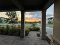Covered porch with view of sunset and neighborhood at 5776 Newberry Pines Ave, Wesley Chapel, FL 33545