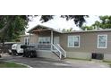 Mobile home with covered porch, golf cart, and landscaping at 6404 Land O Lakes Blvd., Land O Lakes, FL 34638