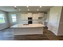 Bright kitchen featuring white cabinets, stainless steel appliances, granite countertops, and a large central island at 18204 Beach Ranch Ter, Lakewood Ranch, FL 34211
