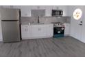 Modern white kitchen featuring stainless steel appliances and gray flooring at 1433 S Belcher Rd # A8, Clearwater, FL 33764