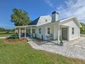 White farmhouse with a wraparound porch, stone walkway, and manicured lawn at 4608 Holbrook Rd, Plant City, FL 33565