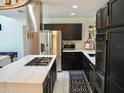 Contemporary kitchen with dark cabinetry and a large island at 26638 Green Willow Run, Wesley Chapel, FL 33544