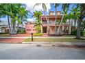 Beautiful two-story house with pink exterior, palm trees, and brick driveway at 825 Islebay Dr, Apollo Beach, FL 33572