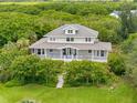 Beautiful home surrounded by lush trees, showcasing curb appeal and serene setting at 1215 Bayshore Dr, Terra Ceia, FL 34250