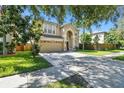 Two story house with tan exterior, two car garage and nicely landscaped lawn at 5707 Butterfield St, Riverview, FL 33578