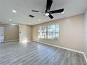 Bright living room featuring wood-look floors and sliding glass doors leading to the patio at 7702 Ivory Ter, New Port Richey, FL 34655