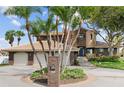 Brick house with three-car garage, palm trees, and circular driveway at 833 Ponce De Leon Dr, Tierra Verde, FL 33715
