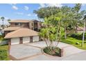 Brick home with a three-car garage, lush landscaping, and a boat dock at 833 Ponce De Leon Dr, Tierra Verde, FL 33715