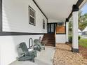 Front porch with Adirondack chairs and a view of the landscaped yard at 9913 Alavista Dr, Gibsonton, FL 33534