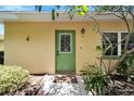 Front door view of a light yellow house with a green door at 401 Dorchester Pl # 58, Sun City Center, FL 33573
