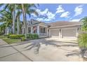 Charming home with a well-manicured lawn, a three-car garage and a welcoming front porch at 617 Islebay Dr, Apollo Beach, FL 33572