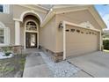 Two-story house with tan siding, large driveway, and landscaped yard at 13951 Caden Glen Dr, Hudson, FL 34669