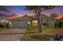 Evening view of charming one-story house with landscaped yard at 1839 Sunrise Dunes Ct, Tarpon Springs, FL 34689