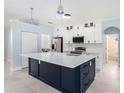 Modern kitchen with large island, white cabinets, and stainless steel appliances at 1839 Sunrise Dunes Ct, Tarpon Springs, FL 34689