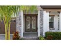 Elegant entryway with double doors and stone detailing at 13029 Paddock Wood Pl, Riverview, FL 33579