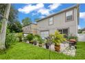 Spacious backyard with patio, lush landscaping, and string lights at 2348 Silvermoss Dr, Wesley Chapel, FL 33544