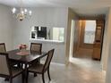 Inviting dining room with chandelier, dark wood table, and a pass-through to kitchen at 120 Knollpoint Dr, Sun City Center, FL 33573