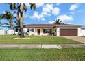Single story home with a paver driveway, landscaped lawn, and two-car garage at 537 Dolphin Se Ave, St Petersburg, FL 33705