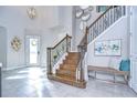 Grand two-story entry with a wooden staircase and tile floors at 2924 Valencia Ridge St, Valrico, FL 33596