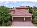 Two-story house with tile roof and two-car garage at 4586 Grand Lakeside Dr, Palm Harbor, FL 34684