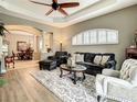 Elegant living room featuring tray ceilings, a large window, and hardwood floors at 4737 Casswell Dr, New Port Richey, FL 34652