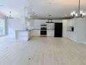 Modern white kitchen with stainless steel appliances, granite countertops, and decorative backsplash at 6924 Greenhill Pl, Tampa, FL 33617