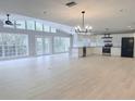 Bright open-concept living area with large windows, vaulted ceilings, and modern kitchen with stainless steel appliances at 6924 Greenhill Pl, Tampa, FL 33617