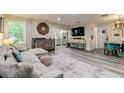 Open living area with a sectional sofa, wood floors, and large TV at 2219 Beach S Blvd, Gulfport, FL 33707