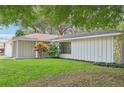 Side view of the house showcasing a light gray exterior and landscaping at 6605 Pointe West Blvd, Bradenton, FL 34209