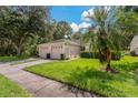 Two-car garage, light beige exterior, and manicured lawn at 34802 Double Eagle Ct, Zephyrhills, FL 33541