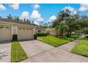 Tan house with two-car garage and lush landscaping at 34802 Double Eagle Ct, Zephyrhills, FL 33541