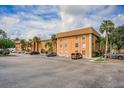 Condominium building exterior with on-site parking, tropical trees, and blue skies at 12760 Indian Rocks Rd # 510, Largo, FL 33774