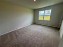 Bedroom with neutral carpet and a large window overlooking the backyard at 18208 Beach Ranch Ter, Lakewood Ranch, FL 34211